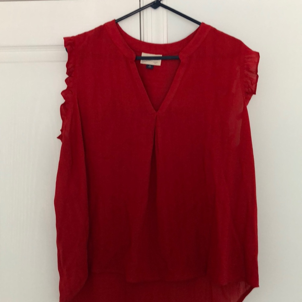 Red sleeveless blouse with ruffled arms.